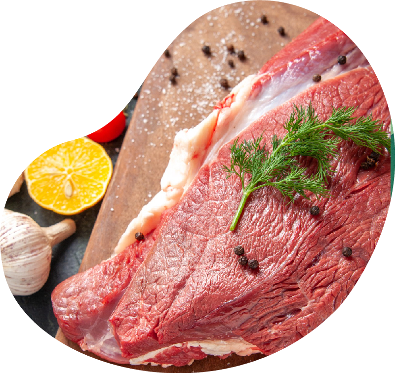 Front close view of fresh raw red meat on wooden cutting board on nude color towel lemon garlic on mixed color background<br />
